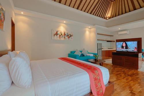 a bedroom with a bed and a flat screen tv at Sanata Luxury Villa in Canggu