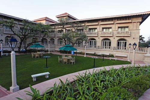 a building with tables and umbrellas in a courtyard at Evershine Resort & Spa in Mahabaleshwar