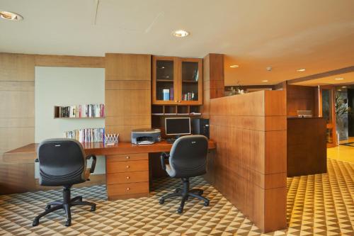 an office with two chairs and a desk with a computer at Wyndham Grand Izmir Ozdilek Thermal & Spa in Izmir