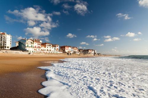 a beach with buildings and the ocean and the waves at VILLA SEA AND SURF in Soorts-Hossegor