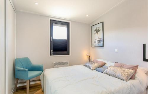 een slaapkamer met een bed en een blauwe stoel bij Nice Home In Voorthuizen With Wifi in Voorthuizen