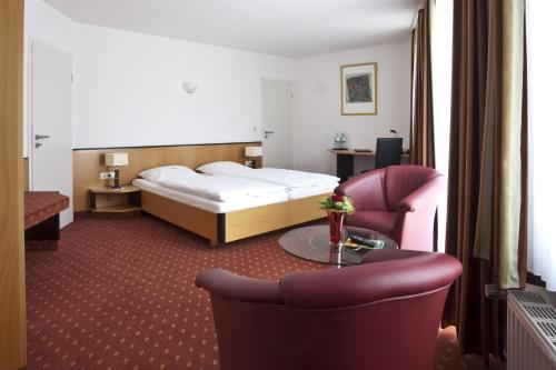 a hotel room with a bed and a table and chairs at Hotel Am Braunen Hirsch in Celle