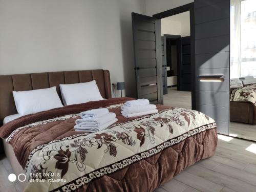 um quarto com uma cama com toalhas em Apartmets Domovik Вместительная трьохкомнатная квартира em Mukacheve