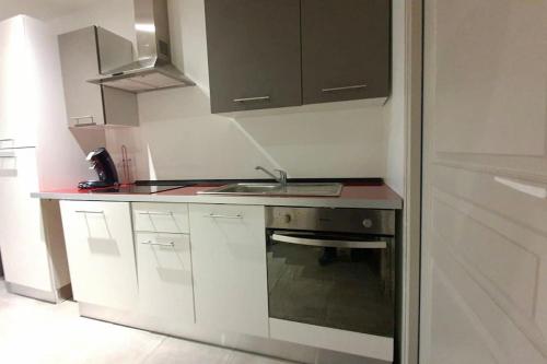 a white kitchen with a sink and a stove at Lumineux appartement duplex, très bien équipé in Saint-Amand-Montrond