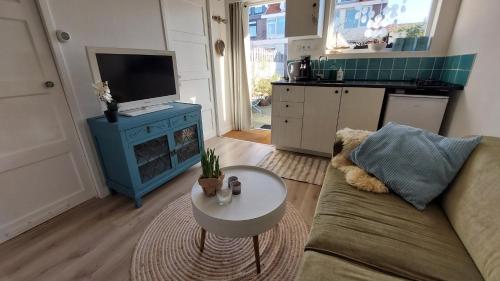 a living room with a couch and a table at Olga's Cottage in Den Helder