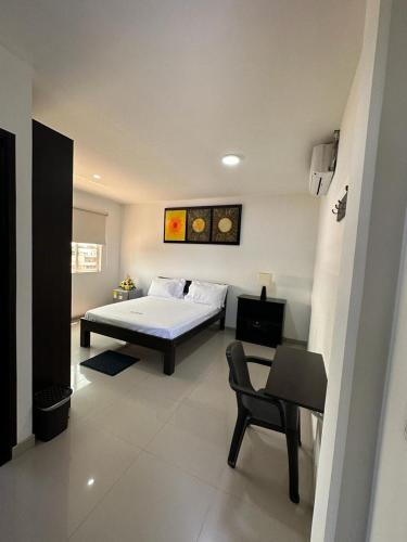 San MartínにあるHotel River Sideのベッドと椅子と机のある寝室