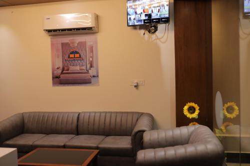 a living room with a couch and a tv at HYDEPARK REGENCY in Palakkad