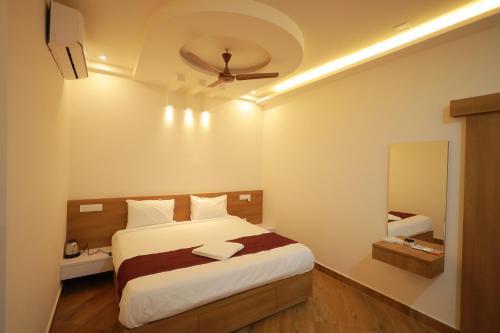 een slaapkamer met een bed en een plafondventilator bij HYDEPARK REGENCY in Palakkad