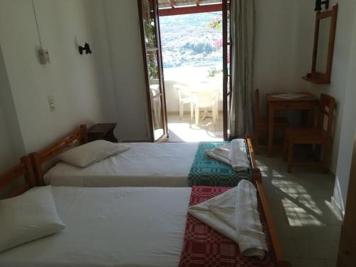 バトシにあるVilla Athinaのベッドルーム1室(ベッド2台付)、パティオへのドアが備わります。