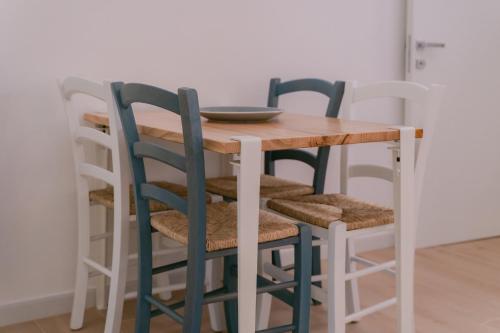 a wooden table with four chairs and a plate on it at Tiny house in the historic centre of Soverato in Soverato Superiore