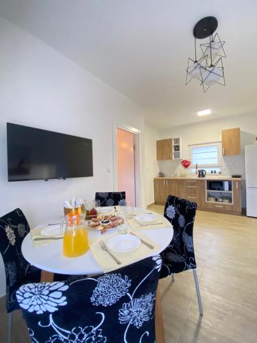 uma mesa de jantar com cadeiras e uma cozinha em Gold Apartments em Skradin