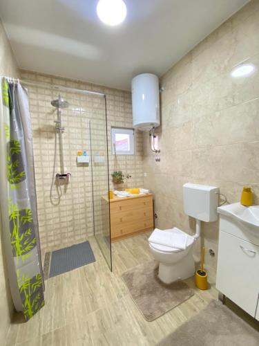 uma casa de banho com um chuveiro, um WC e um lavatório. em Gold Apartments em Skradin