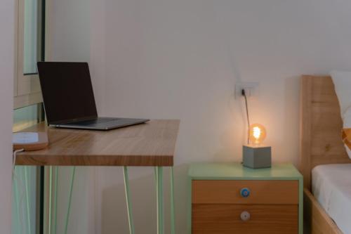 a laptop computer sitting on a desk with a lamp at Tiny house in the historic centre of Soverato in Soverato Superiore