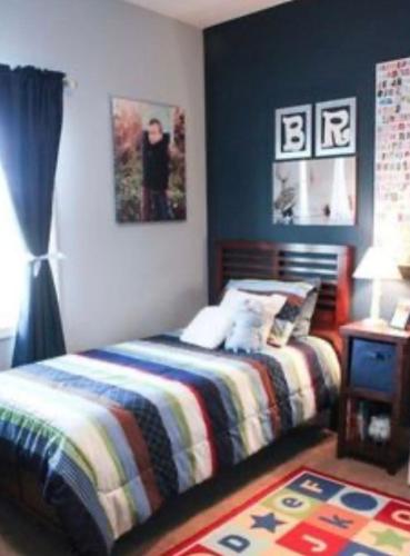 a bedroom with a bed with a striped blanket and a table at Home away from Home in Liverpool