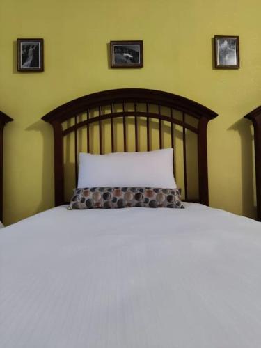 a bed with a wooden headboard and a white pillow at Bascarsija apartment B-Home Old Town Sarajevo in Sarajevo