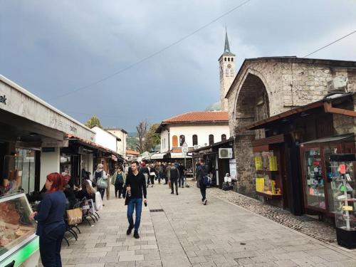 a group of people walking down a street with shops at Bascarsija apartment B-Home Old Town Sarajevo in Sarajevo