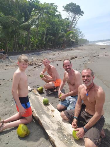 a group of men sitting on the beach eating fruit at Terra NaturaMa - off grid living in the jungle in Punta Uva
