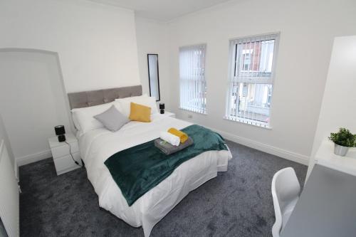 a white bedroom with a bed and two windows at Belfast Cozy Home in Belfast