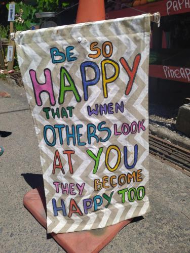 a sign that says be so happy that when others look at you they become happy at Terra NaturaMa - off grid living in the jungle in Punta Uva