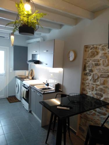 a kitchen with white appliances and a table in it at CASA SYRA in Ermoupoli