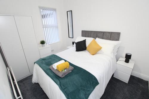 a bedroom with a large white bed with yellow pillows at Belfast Cozy Home in Belfast