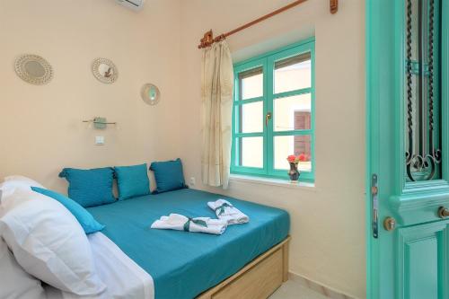Rhodes Heaven Apartment في Malona Village: غرفة نوم بسرير ازرق عليها مناشف
