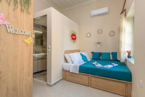 Rhodes Heaven Apartment في Malona Village: غرفة نوم بسرير ازرق وحمام