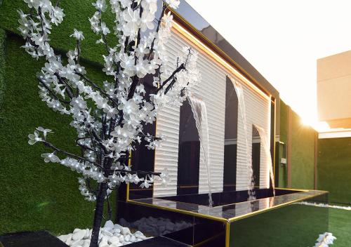 a tree with white flowers in front of a building at الدانة للشقق الفندقية in Kuwait