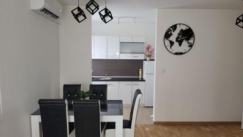 uma cozinha e sala de jantar com mesa e cadeiras em Apartman TEJA DELUXE em Vrnjačka Banja
