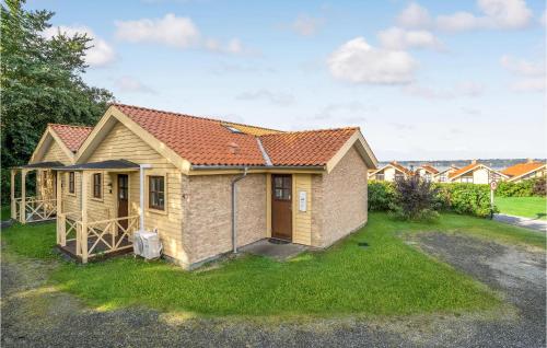 una casa con un patio verde delante de ella en Stunning Home In Egernsund With Kitchen, en Egernsund