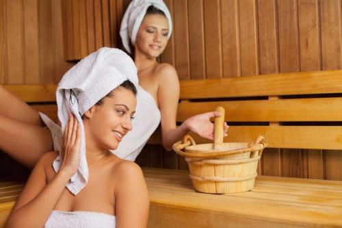 two women in a sauna with towels on their heads at Aparthotel Seepanorama in Mirow