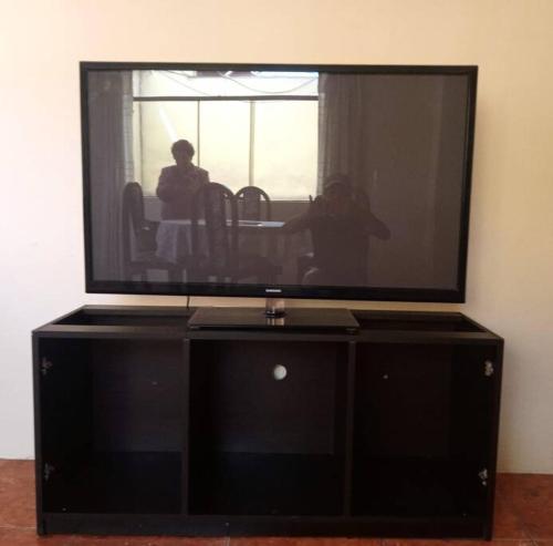 a large flat screen tv sitting on top of a cabinet at Departamento Independiente en Tacna in Tacna