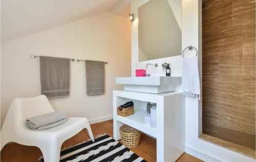uma casa de banho branca com um espelho e uma cadeira em Stunning Home In Split With Outdoor Swimming Pool em Split