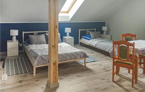 1 Schlafzimmer mit 2 Betten, einem Tisch und einem Stuhl in der Unterkunft Stunning Home In Smoldzinski Las With Wifi in Smołdziński Las