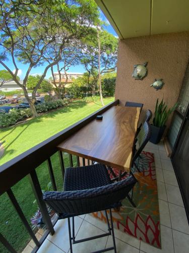 a table and chairs on a balcony with a view at Maui-LICIOUS by the Beach in Kihei
