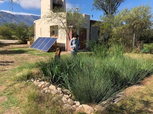 un hombre y un perro en un campo con un panel solar en Casa liquen en San Javier