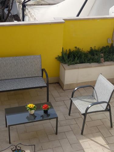 a patio with two chairs and a table with flowers on it at Arra Camere Sirolo - Rooms & Suite in Sirolo