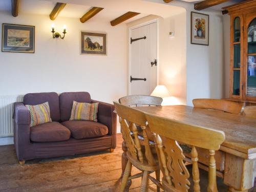 a living room with a wooden table and a couch at Pump Cottage in Brancaster