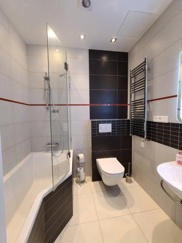 a bathroom with a tub and a toilet and a sink at Prague Centre Apartments in Prague
