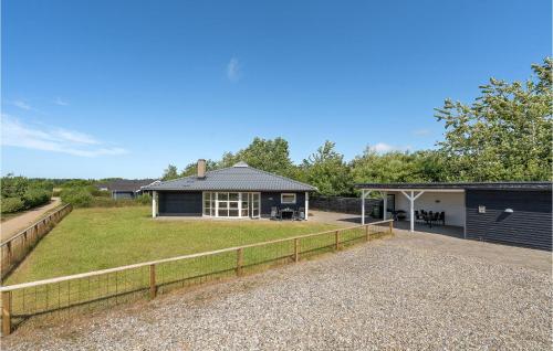 una casa con un gran patio y una valla en Holiday Home Tranebærvej Denm, en Hemmet