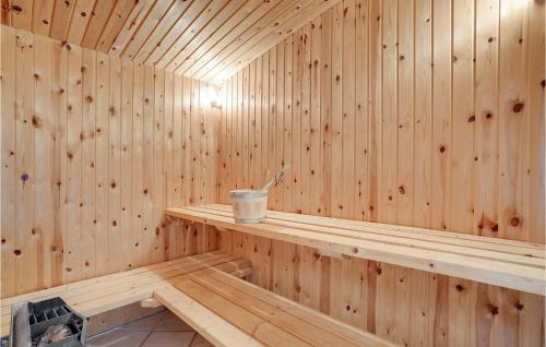 a wooden sauna with a bucket sitting on a shelf at Gorgeous Home In Tarm With Sauna in Hemmet