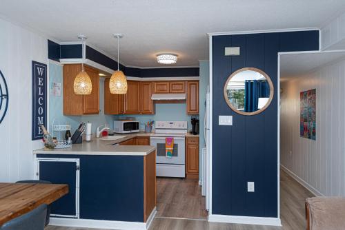 a kitchen with wooden cabinets and a blue wall at Fenwick Woods OC in Ocean City
