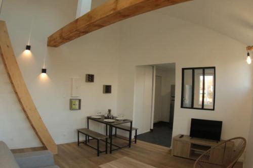 sala de estar con mesa y TV en Logement indépendant appartement T2 bis style loft, en La Vraie-Croix