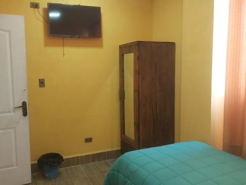 a bedroom with a bed and a tv on the wall at Beliz Inn in Uyuni