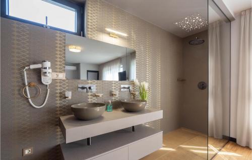 een badkamer met 2 wastafels en een spiegel bij Amazing Home In Jesenice With Kitchen in Jesenice
