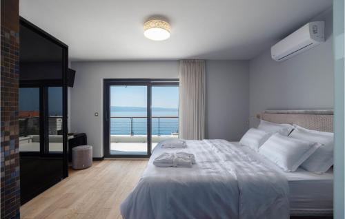 een slaapkamer met een bed en uitzicht op de oceaan bij Amazing Home In Jesenice With Kitchen in Jesenice