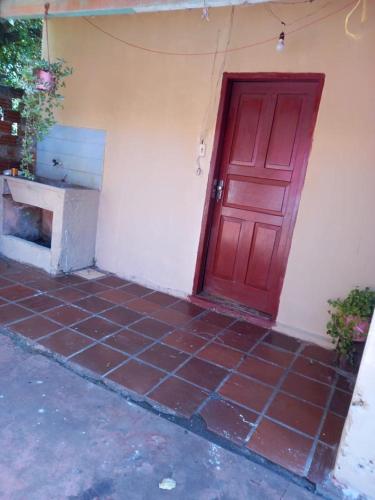 una puerta roja en el lateral de un edificio en Hospedaje Doña Elida, en Encarnación