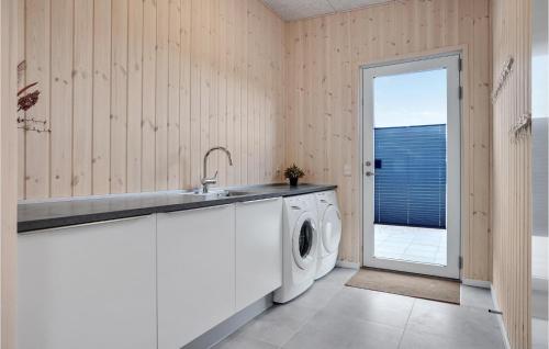 een wasruimte met een wastafel en een wasmachine bij 6 Bedroom Stunning Home In Glesborg in Glesborg
