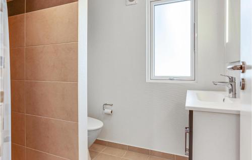 baño con aseo y lavabo y ventana en Gorgeous Home In Stege With Sauna, en Stege