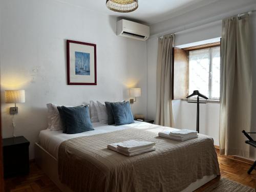 a bedroom with a large bed with towels on it at Cascais center House with garden in Cascais